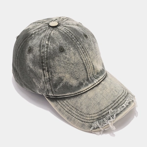 Detailed close-up of distressed brim and snow-washed denim texture on a baseball cap