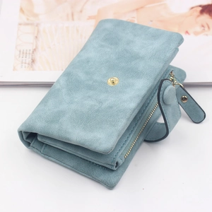 Close-up of matte pale blue trifold wallet with metal snap closure and leather zipper pull