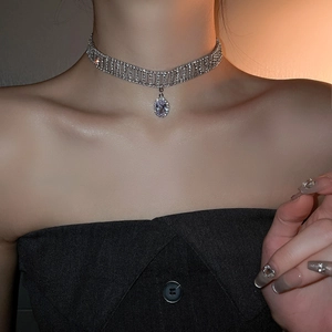 Macro shot of silver-plated choker necklace featuring multi-row rhinestones and teardrop pendant
