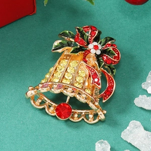 Detail of Christmas bell brooch with golden alloy base and red crystal accents