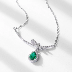 S925 silver necklace with bow design and pear-cut emerald drop pendant surrounded by diamonds