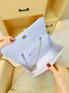 Dettaglio interno della borsa bianca con paillettes e tracolla a catena argento