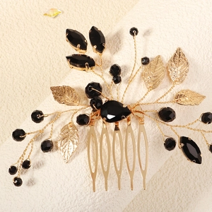 Detail of handcrafted bridal hair comb with black rhinestones and gold leaf branch