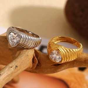 Detailed macro view of gold and silver heart zircon rings on dry wooden branches