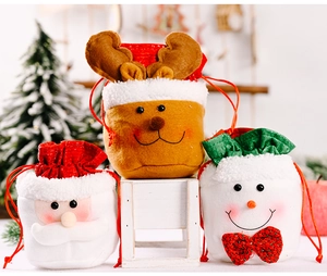 Three festive Christmas plush drawstring gift bags featuring Santa, snowman, and reindeer