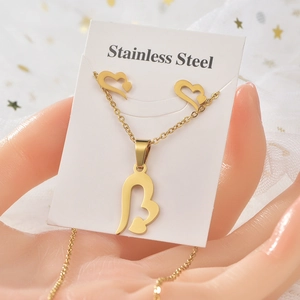 Detail of gold stainless steel jewelry set with heart pattern on display card