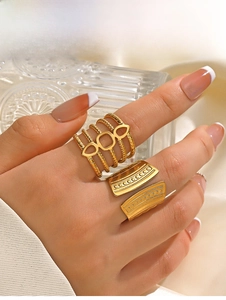 Detail of 18K gold plated geometric ring with spiral texture and dot relief on model