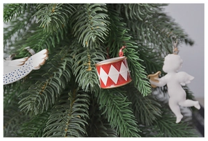 Detailed view of red plaid drums and white angel ornaments on a green pine Christmas tree