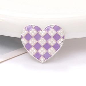 Detail of lilac purple heart charm with checkerboard pearl pattern and silver metal edge