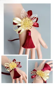 Detail of Chinese wedding wrist corsage with red ribbon, golden flower, and tassel