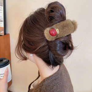 Detailed view of plush autumn hair clip with a Lucky metal charm and red bead accent