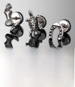 Detail of silver titanium steel earrings set featuring mermaid and turtle designs