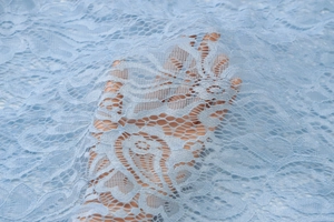 Vista dettagliata del tessuto in pizzo azzurro con intricati motivi traforati