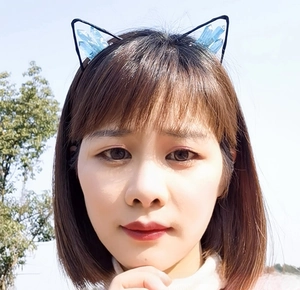 Close-up of cat ear headband featuring light blue crystals on a black wire frame