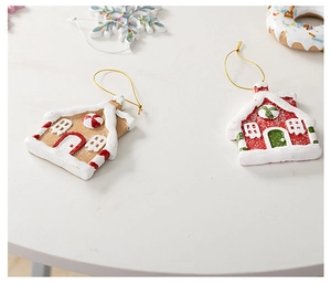Detailed macro view of resin gingerbread house ornaments with snowy finish and gold string