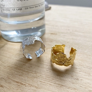 Detail of irregular textured S925 sterling silver rings in gold and silver finish