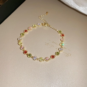 Macro shot of gold-plated bracelet with colorful round zircons and adjustable chain