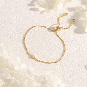 Detail of adjustable gold slider bracelet with starburst pendant and box chain