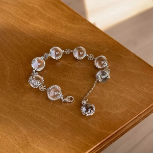 Elegant crystal bead snowflake bracelet with silver finish on a wooden background