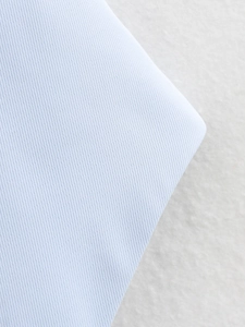 Vue macro de la texture du tissu sergé bleu clair pour débardeur ajusté femme