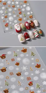Macro shot of 3D embossed Christmas nail art stickers featuring bears and Santa Claus