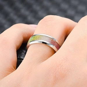 Detailansicht eines modischen Herrenrings mit farbenfrohem Glitzer-Inlay an der Hand