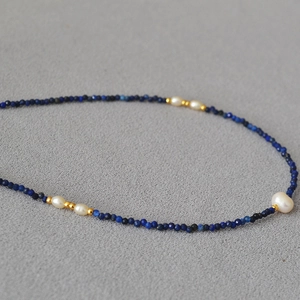 Detail of lapis lazuli beads and rice pearls on a minimalist handmade gold necklace