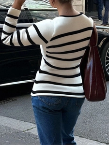 Vue arrière d'un élégant pull en maille rayé à manches longues porté avec un jean bleu chic