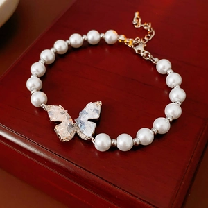 Détail d'un bracelet en perles avec cristal papillon et fermoir mousqueton ajustable