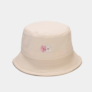 Detailed close-up of cherry blossom embroidery on a beige cotton bucket hat for women