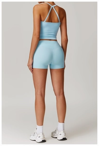 Détail d'un ensemble de yoga bleu clair avec brassière à dos croisé et short taille haute