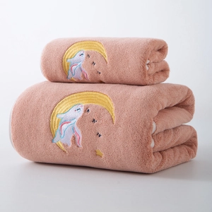 Close-up of pink coral fleece bath towel with embroidered sleeping bunny and yellow moon