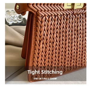 Detailed close-up of brown woven texture and gold metallic lock on a fashion handbag