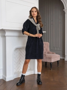 Detail of navy corduroy dress featuring textured fabric and adjustable buttoned sleeves