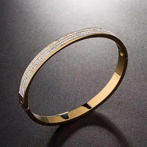 Elegant rose gold titanium bangle with three rows of sparkling zircon stones on a dark surface