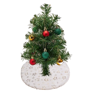 Mini green Christmas tree with colorful ornaments and white star-patterned tree skirt