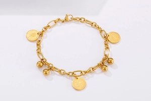 Dettaglio del bracciale a catena dorata con ciondoli a moneta e perline su bianco