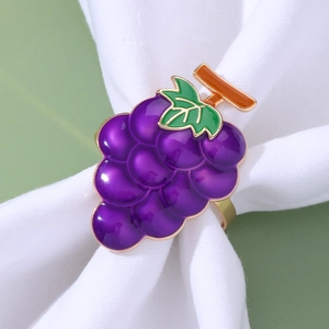 Macro shot of purple enamel grape napkin ring with green leaves and metallic finish