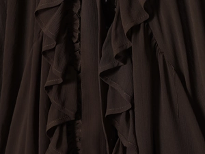 Close-up of layered dark brown chiffon ruffles and pleated fabric texture on a casual blouse