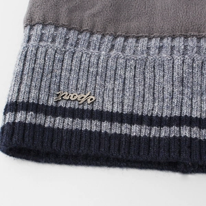 Detail of gray fleece lining and knit edge with sport metal tag on winter beanie