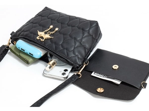 Internal capacity view of black crossbody bag with heart embroidery and mini pouch