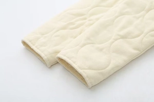 Detailed macro shot of the quilted seams and durable fabric texture on the beige jacket