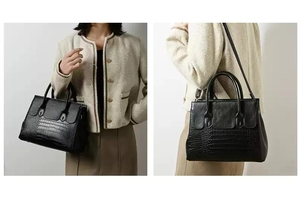 Detail of black faux crocodile leather handbag with double handles and slim shoulder strap