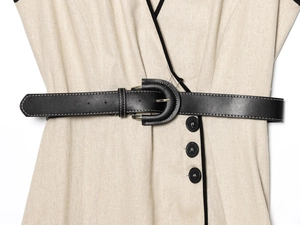 Detail des beige Leinenkleids mit schwarzer Paspelierung und Ledergürtel mit Ziernaht