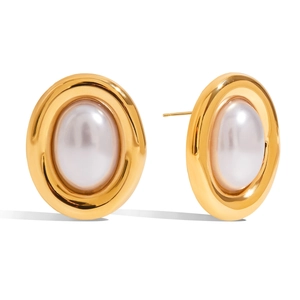 Vintage gold oval stud earrings with white faux pearl insets on a white background