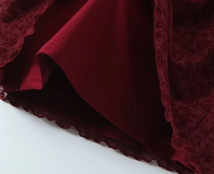 Detailed macro shot of burgundy flocked fabric with lace hem and smooth lining