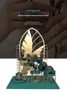 Green velvet and gold metal watch display stand with tiered base and leaf screen