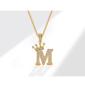 Dettaglio della collana con ciondolo lettera M corona d'oro e pavé di zirconi lucidi