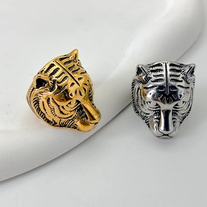 Macro view showing the intricate texture of tiger head rings in gold and silver finishes