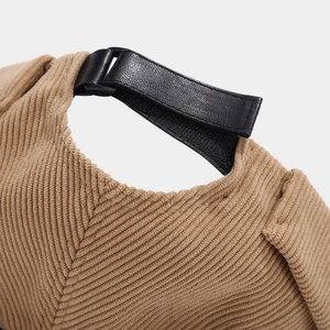 Macro shot of khaki corduroy fabric and black leather adjustable strap on hat